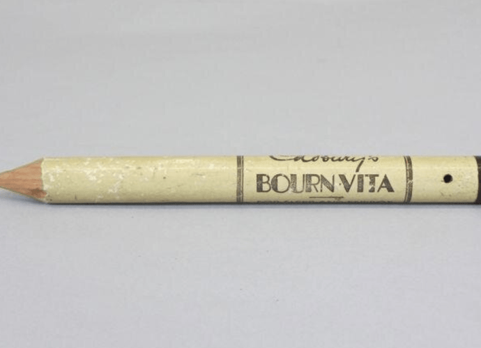 Giant pencil made of wood, painted cream and printed in brown with the words 'Cadbury's BOURNVITA FOR SLEEP AND ENERGY'.
